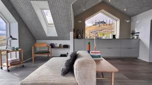 a living room with a couch and a table at Beitisstova - Mesmerizing Sea & Mountain Views in Stykkið