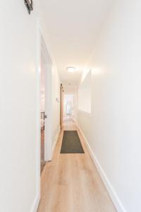 a hallway with white walls and a rug on the floor at 72 S Orem Entire Home in Orem +77 photos