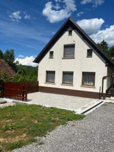a white house with a black roof at Apartma Hiška Vrh in Stari Trg pri Ložu
