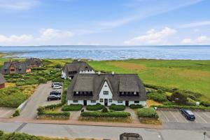 an aerial view of a house with cars parked in a parking lot at Wattkieker-Stedum in Rantum