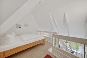 a white room with a bed and a window at Wattkieker-Stedum in Rantum