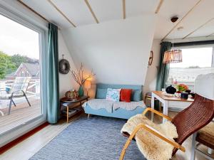 a living room with a couch and a table at Nordlicht, 1-Zimmer mit Meerblickbalkon 500 m zum Strand in Westerholz +33 photos