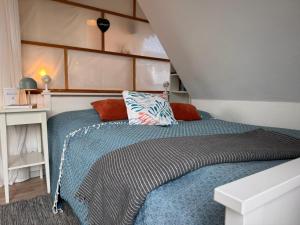 a bedroom with a bed with a blue comforter at Nordlicht, 1-Zimmer mit Meerblickbalkon 500 m zum Strand in Westerholz
