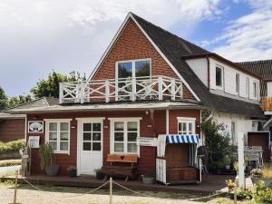 a house with a balcony on top of it at Nordlicht, 1-Zimmer mit Meerblickbalkon 500 m zum Strand in Westerholz
