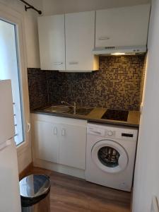 a kitchen with a washing machine and a sink at Studio UN Hagoort in Agde