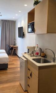 a kitchen with a sink and a bed in a room at City Center Jerusalem in Jerusalem