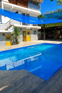 a blue swimming pool in front of a building at Huiltana ecohotel&resort in Guataquí