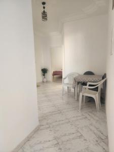 a room with a table and chairs and a room with a couch at F3 entre nature et calme in Raʼs al Jabal