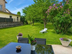 a patio with a table and chairs in a yard at Le marcquis in Marcq
