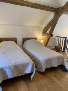 two beds sitting next to each other in a bedroom at Le marcquis in Marcq