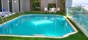 a large blue swimming pool on a balcony with chairs at Double Room with Private Bathroom near Dubai in Sharjah +70 photos
