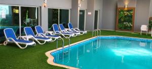a hotel room with a pool and lounge chairs at Double Room with Private Bathroom near Dubai in Sharjah