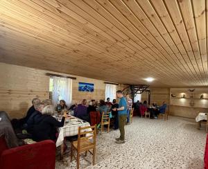 a group of people sitting at tables in a room at Bata GuesThouse in Adishi +50 photos
