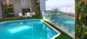 a swimming pool on top of a building with a balcony at Double Room with Private Bathroom near Dubai in Sharjah