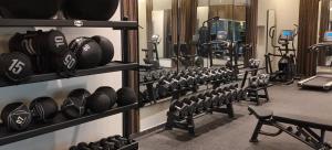 a gym with rows of dumbbells on the wall at Double Room with Private Bathroom near Dubai in Sharjah