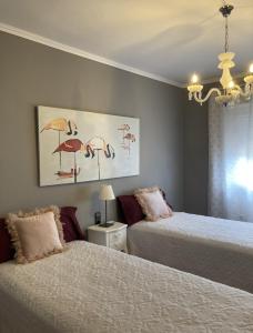 a bedroom with two beds and a painting of flamingos at Villa Bo in Deltebre +38 photos