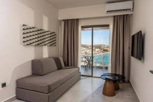 a living room with a couch and a view of the ocean at Scala Boutique Hotel & Suites - Adults Only in Agia Pelagia