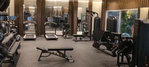 a gym with a bunch of treadms and machines at Double Room with Private Bathroom near Dubai in Sharjah