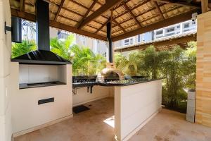 a kitchen with an outdoor kitchen with a stove at Até 4 Hóspedes, Elevador, Varanda C/Frente Piscina Jr Catito in Brasília