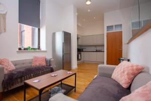a living room with two couches and a table at Stunning City Centre Duplex in Glasgow