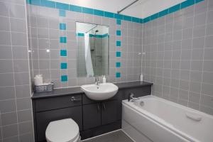 a bathroom with a sink and a toilet and a bath tub at Stunning City Centre Duplex in Glasgow
