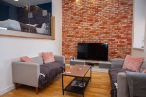 a living room with two couches and a flat screen tv at Stunning City Centre Duplex in Glasgow