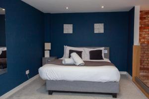 a bedroom with blue walls and a large bed at Stunning City Centre Duplex in Glasgow +11 photos