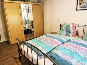a bedroom with two beds and a mirror at Apartment Krüger-1 by Interhome in Großheide +8 photos