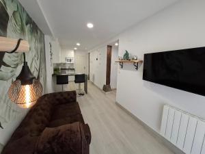 a living room with a couch and a television on a wall at La Capital del Mundo in Arredondo