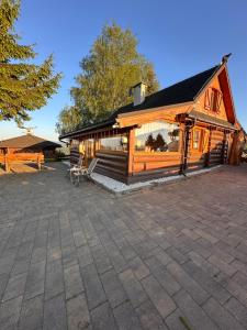 a large wooden building with a patio in front of it at Nasza Chata in Jaworzynka