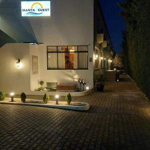 a building with a bench on a street at night at Manta Guest - Manta Rota Beach in Manta Rota