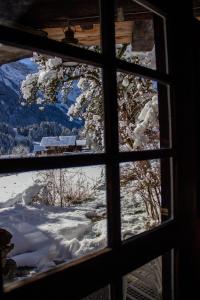 a window with a view of a snowy mountain at Le Mazot des Révines - 2 pers in Champéry +2 photos