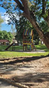 a playground in a park with a tree at Casa c ar cond, wifi, a 5 min Orla da Lagoa Para Famílias in Araruama