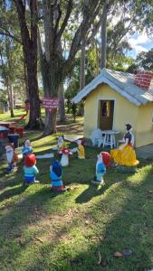 a group of toy figurines in the grass in front of a house at Casa c ar cond, wifi, a 5 min Orla da Lagoa Para Famílias in Araruama