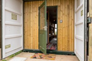 an open door to a room with wooden walls at Container 2, Camp Tapnell in Yarmouth