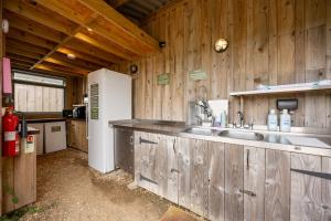 a kitchen with a sink in a wooden cabin at Container 2, Camp Tapnell in Yarmouth