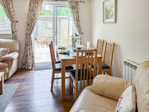 a living room with a dining room table and chairs at Rose Cottage in Upper Rissington