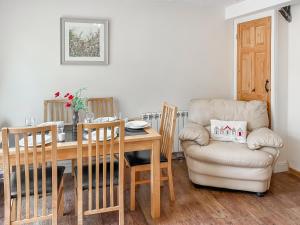 a dining room with a table and a chair at Rose Cottage in Upper Rissington