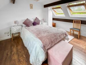 a bedroom with a large bed and two windows at Rose Cottage in Upper Rissington +10 photos