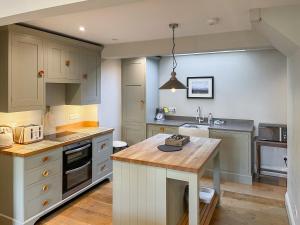 a kitchen with white cabinets and a wooden counter top at St Anthonys in Ampleforth