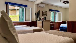 a hotel room with two beds and a window at Hotel Savoy Excellence in Campos do Jordão +90 photos
