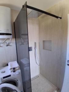 a bathroom with a shower and a washing machine at Apartment Matija in Stara Novalja