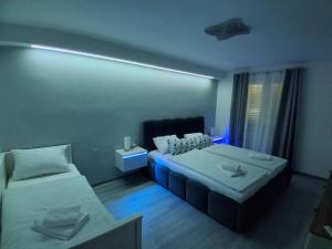a bedroom with two beds and a blue light at Apartment Matija in Stara Novalja