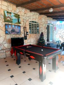 a pool table in a room with a stone wall at Casa com Natureza in Goiânia