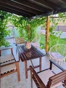 a wooden table and chairs under a pergola at Tiny Loft House in Halkidiki in Nea Potidaea +66 photos