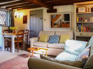 a living room with a couch and a table at Pond Cottage in Alton