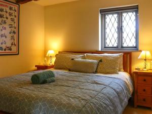 a bedroom with a bed with yellow walls and two lamps at Pond Cottage in Alton +13 photos