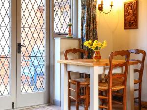 a dining room table with chairs and a vase of flowers at Pond Cottage in Alton