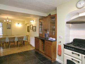 a kitchen with an oven and a table with chairs at The Captains House in Instow