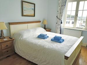 a bedroom with a bed with two blue towels on it at The Captains House in Instow